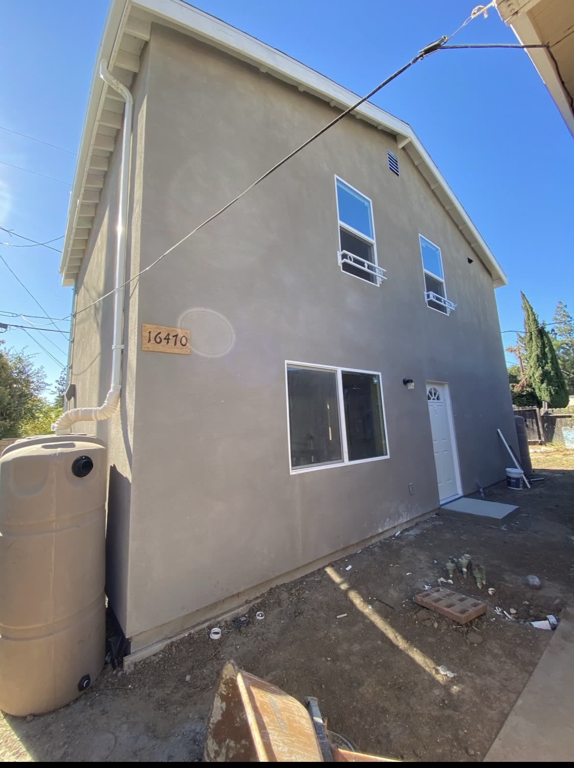 Two-story gray stucco ADU built on a compact lot